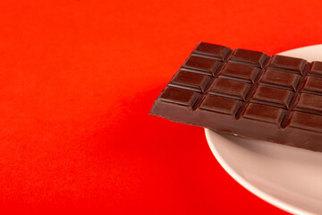 Chocolate with plate on red background
