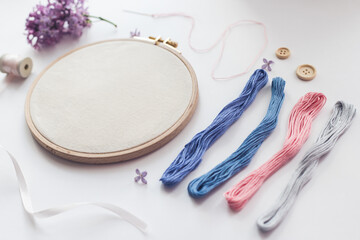 Flat lay top view photo of a mockup with embroidery hoop and llilac flowers.