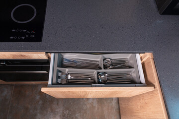 Top down view of a grey stone kitchen counter with open drawer