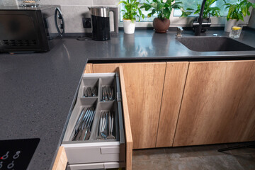 Fototapeta na wymiar Open cutlery drawer in a modern fitted kitchen in a home