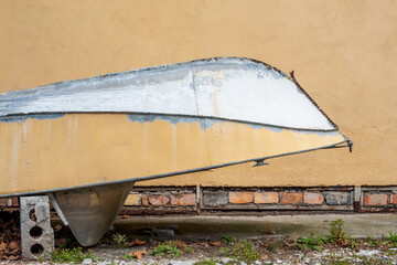 beige inverted boat against the background of a beige wall. boat in storage