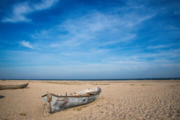 Old rusty boats on the beach sand of the morning sea