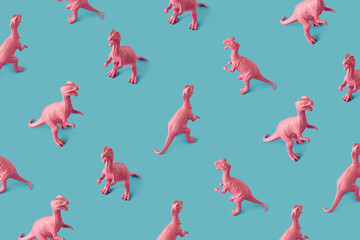 Obraz premium Creative isometric pink painted dinosaur toy pattern on blue background. Minimal abstract concept for school and kids.
