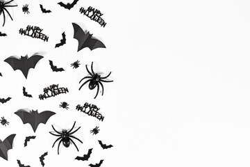 Halloween bats, spiders, flies and Happy Halloween text on side of white background with copy space