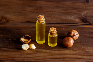 Macadamia nut oil in glass bottle with nuts. Essence extra virgin oil for food or cosmetic