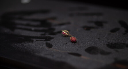 Dry roses on black dusty surface with fingerprints on dust. Sandess, loneliness and the end