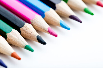School stationery items. Creation Multicolored pencils on a blank white sheet. On a white...