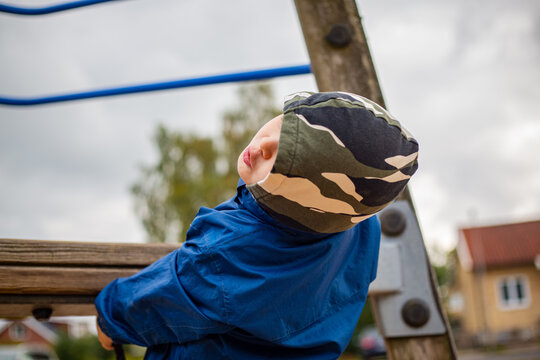 Boy in blue jacket and a military pattern hoodie
