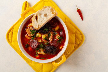 Traditional Spanish goulash soup. Fabada Asturiana. Served with a yellow clay pot with lid. Top...