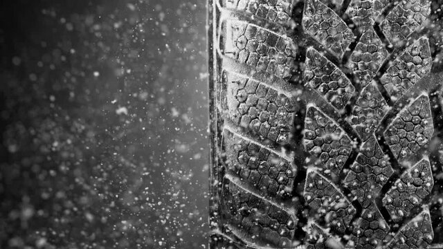Super slow motion of falling snow on tire sample, close-up, free space for text. Filmed on high speed cinema camera, 1000 fps.