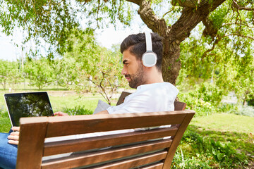 Man in the park or garden at the laptop computer