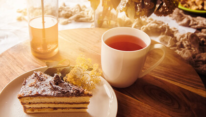 tea with piece of sponge cake decorated with chocolate served for breakfast in the morning at home or in a hotel, enjoying life and yummy food concept.