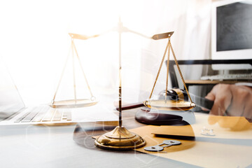 law legal technology concept. judge gavel on computer with scales of justice on desk of lawyer.