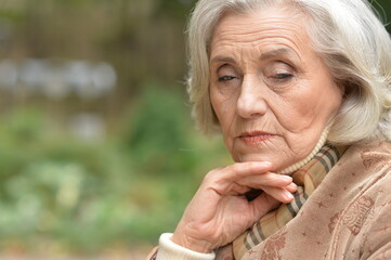 sad, thoughtful  senior woman in  park