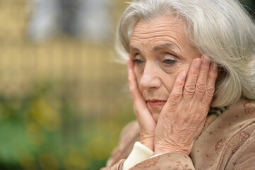 sad senior woman in  park