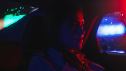Close Up Portrait of a Female Commuting Home in a Backseat of a Taxi at Night. Beautiful Woman...