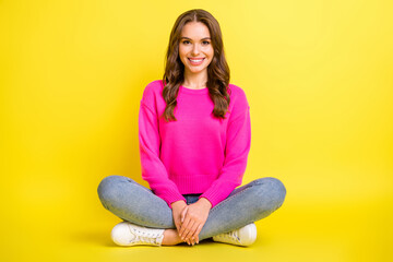Full size photo of young happy positive good mood girl smiling sit floor with crossed legs isolated on yellow color background