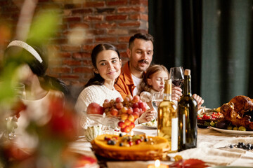 Close-up happy family, married couple celebrate Thanksgiving day, sitting at table with holiday...