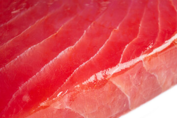 Macro shot yellow fin tuna steak background. Fresh rare tuna steak close up. Raw yellowfin tuna fillet texture pattern. Background fresh tuna meat surface. Slices of tuna meat.