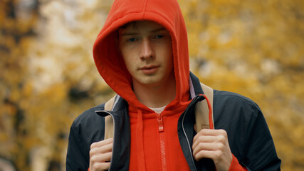 Sad caucasian teenager boy with backpck outdoors in autumn park © nimito