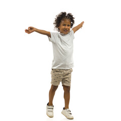 Happy small black boy is standing with arms outstretched. Full length, isolated.
