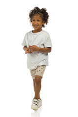 Small black boy in shorts and shirt is looking away. Full length, isolated. - 461674858