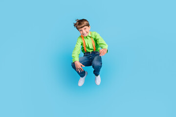 Full length body size view of attractive cheerful funny boy jumping having fun isolated over teal turquoise color background