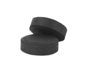 Activated charcoal pills on white background. Potent sorbent
