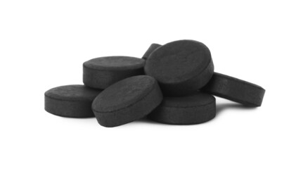Activated charcoal pills on white background. Potent sorbent