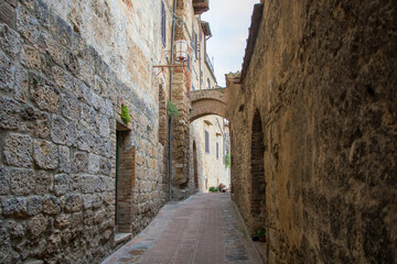 Fototapeta na wymiar Enge Gasse mit Torbogen in der Altstadt von San Gimignano