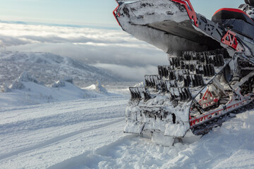a truck of a sports snowmobile in close-up against the background of a mountain valley. the concept of recreation on a mountain snowmobile in winter