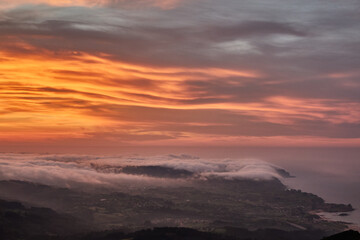 Clouds descend over Playa de la Isla at sunset. Asturias. Spain