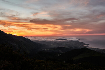 Fototapeta na wymiar Clouds descend over Playa de la Isla at sunset. Asturias. Spain