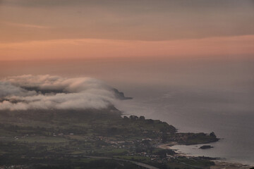 Clouds descend over Playa de la Isla at sunset. Asturias. Spain