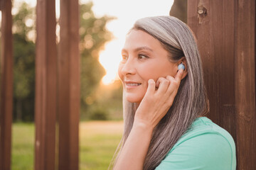 Profile side view portrait of attractive cheerful dreamy grey-haired woman listening music talking...