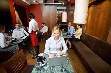 Young business woman using laptop at table in coffee shop