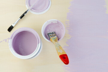 Mauve paint pot and brush on yellow background. Copy space.