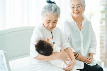 赤ちゃんを抱っこするシニア女性たち