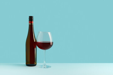 Bottle and glass of red wine on blue background. Mock up drink with place for you lable and text