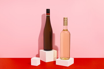 Bottles of wine on red and pink background with deep shadows. Mock up drink with place for you lable and text