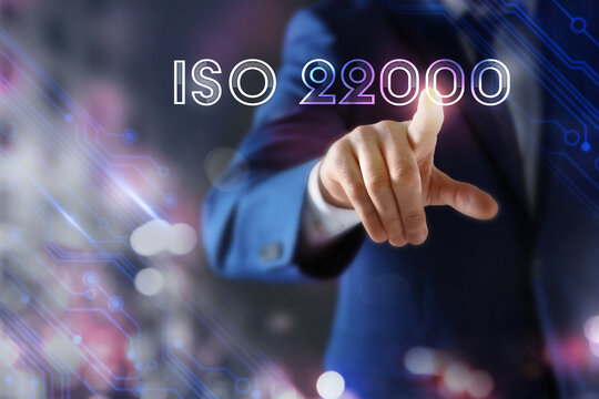 Man pointing at virtual screen with text ISO 22000, closeup