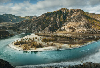 Confluence of Chuya and Katun rivers. Larch forest on the bank of the river.