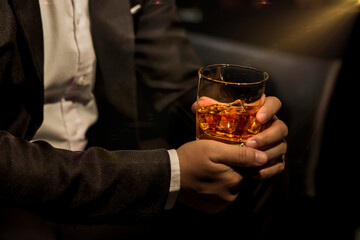 Closeup businessmen holding a glass of whiskey