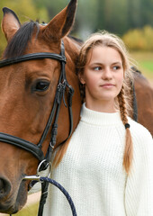 Obraz premium Young girl walking with a horse in nature