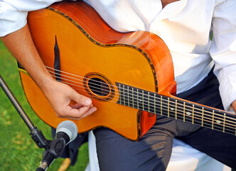 Musician playing a Spanish guitar. Outdoor acoustic music concert. Live performance of a flamenco guitarist outdoors - obrazy, fototapety, plakaty