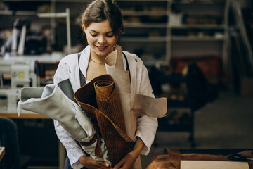 Woman tailor working on leather fabric