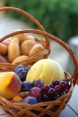 Two baskets full of fresh fruit and vegetable in a garden. Selective focus.