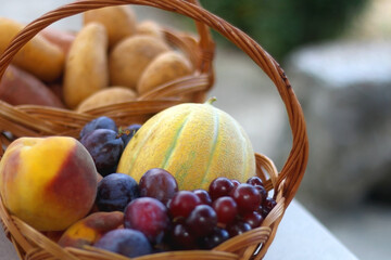 Two baskets full of fresh fruit and vegetable in a garden. Selective focus.