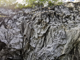 View from the water on the steep slope of the flooded Marble Canyon in the Ruskeala Mountain Park on a sunny summer day.