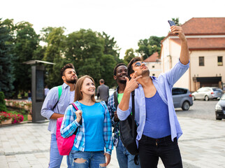 The joyful group of students taking a selfie outdoors